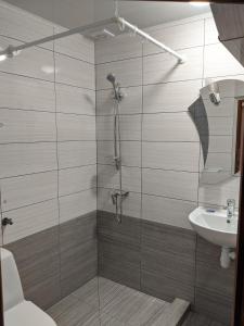 La salle de bains est pourvue d'une douche, d'un lavabo et d'un parasol. dans l'établissement Gostynna Rodyna, à Izki