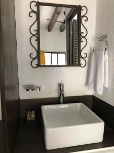 bagno con lavandino bianco e specchio di Hotel Antigua Posada a Cuernavaca