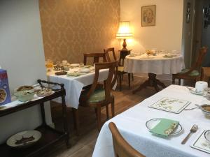 un comedor con 2 mesas con manteles blancos en Crammond House en Ramelton