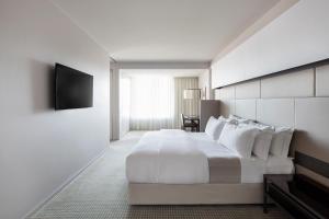 a hotel room with a large bed and a large window at Hotel Realm in Canberra