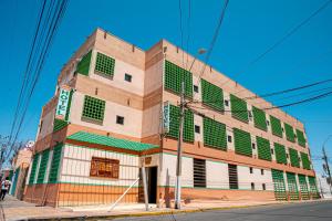 un edificio con ventanas verdes y blancas en una calle en Ayelen Apart Hotel, en Calama