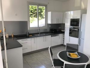 a kitchen with a table with a bowl of bananas on it at Location Vacances in Deshaies