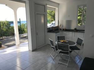 a kitchen with a table and chairs with a view at Location Vacances in Deshaies