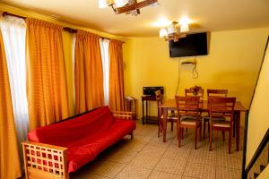 a living room with a red couch and a table at Ayelen Apart Hotel in Calama