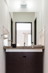 a bathroom with a sink and a large mirror at El Cairo 10 in Puerto Madryn