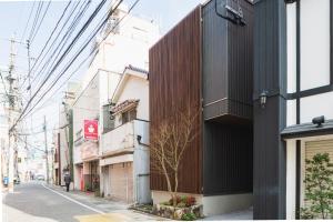 a building with a wooden facade on a city street at The LOFT INN NAGASAKI in Nagasaki