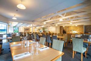 uma sala de jantar com mesas e cadeiras de madeira em Heartland Hotel Queenstown em Queenstown