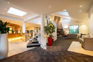 a lobby with stairs and a plant in a building at Heartland Hotel Queenstown in Queenstown