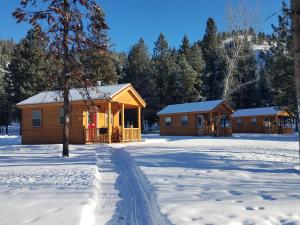 una cabaña de madera en la nieve con entrada en The Wild Game Inn, en Alta