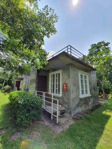 a small house in a yard with a tree at Hip Home at Hod in Hot
