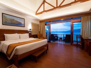 ein Schlafzimmer mit einem Bett und einem großen Fenster in der Unterkunft Sunlight Ecotourism Island Resort in Culion Reservation