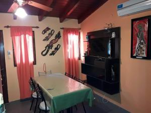 a dining room with a table and a tv and a table and chairs at Ariel Reynoso - Departamento Planta Baja in Mina Clavero