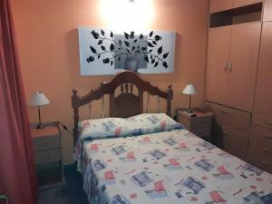 sypialnia z łóżkiem z drewnianym zagłówkiem w obiekcie Ariel Reynoso - Departamento Planta Baja w mieście Mina Clavero