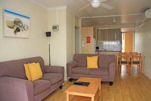 a living room with two couches and a table at Waterview Apartments in Port Macquarie