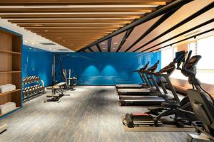 a gym with a row of treadms and cardio machines at Evergreen Palace Hotel Chiayi in Taibao