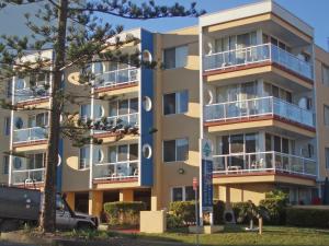 a large apartment building with a van parked in front of it at Waterview Apartments in Port Macquarie