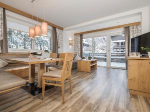 a dining room and living room with a table and chairs at Apart Garni Montana in Pertisau