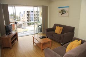 a living room filled with furniture and a tv at Waterview Apartments in Port Macquarie