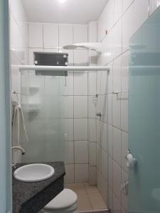 ein weißes Badezimmer mit Toilette und Waschbecken in der Unterkunft Apartamento Exclusivo - Hospedes in Joinville