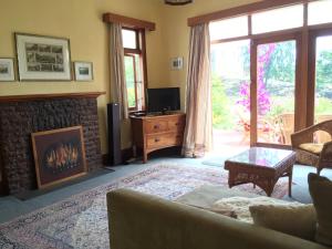 a living room with a fireplace and a tv at Tasman Farmstay Retreat GlenMhor in Tasman