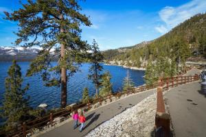 two people walking along a path next to a lake at Cedars West in Incline Village