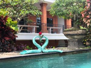 a mermaid statue sitting next to a swimming pool at Ayu Bungalow 2 in Ubud