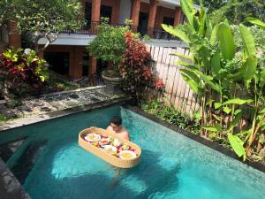 a man in a boat in a swimming pool at Ayu Bungalow 2 in Ubud
