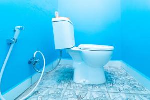 een badkamer met een toilet in een blauwe kamer bij KoolKost At Menceng Raya - Minimum Stay 30 Nights in Jakarta