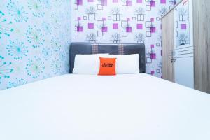 een slaapkamer met een bed met een oranje kussen erop bij KoolKost At Menceng Raya - Minimum Stay 30 Nights in Jakarta