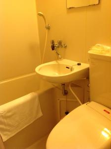 uma casa de banho com um lavatório, um WC e uma banheira em Jonai Hotel em Karatsu