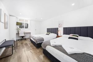 a bedroom with two beds and a desk and a chair at Appin Village Motel in Appin