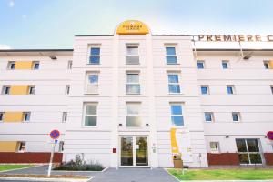 een wit gebouw met een bord erop bij Premiere Classe Lisieux in Lisieux