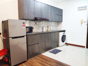 a kitchen with a refrigerator and a washing machine at Parkview KLCC by Salaam Suites, 4 pax in Kuala Lumpur