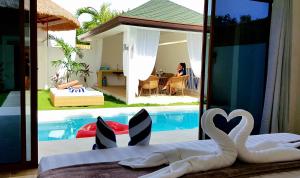 a room with a swimming pool and a bed with swans at Montecarlo Villas Panglao in Panglao Island