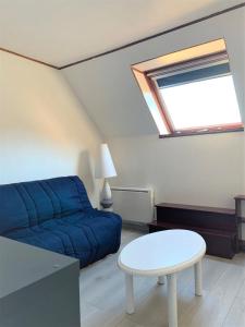 uma sala de estar com um sofá azul e uma mesa em Appartement 3p luchon cures & ski Soda em Luchon