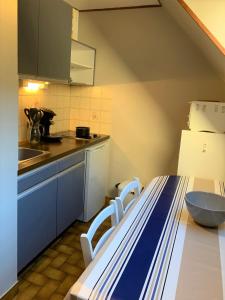 uma cozinha com uma mesa, 2 cadeiras e um lavatório em Appartement 3p luchon cures & ski Soda em Luchon