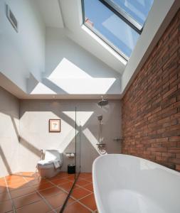 a bathroom with a toilet and a brick wall at El Barrio Lanna in Chiang Mai