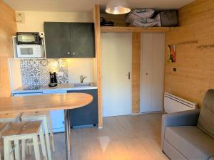 a small kitchen with a table in a tiny house at L'esprit chalet by SODA in Luchon