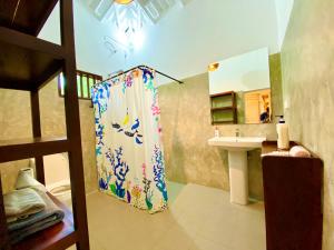 a bathroom with a shower curtain and a sink at The Horizon Hill Top Villa in Unawatuna