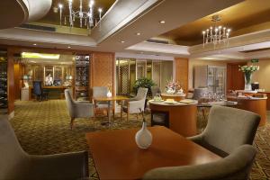 Dalian East Hotel في Jinzhou: لوبي فندق فيه طاولات وكراسي