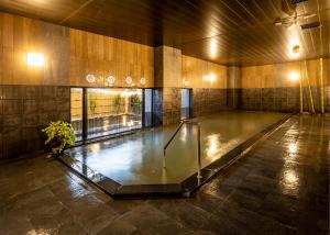 a swimming pool in a building with a glass floor at Hotel Route-Inn Wajima in Wajima