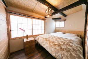 een slaapkamer met een bed en een groot raam bij Nishodo Machiya HIKARU GOJO in Kyoto