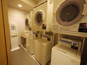 a laundry room with several washers and dryers in it at Hotel Route-Inn Wajima in Wajima