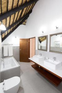 a bathroom with two sinks and a tub and a toilet at Kruger Park Lodge Unit No. 608A in Hazyview