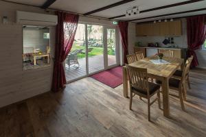 a kitchen and dining room with a wooden table and chairs at Kiviranna puhkemajad in Suure-Rakke