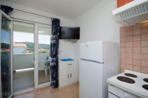 a small kitchen with a refrigerator and a window at Holiday S&M in Lopar +31 photos