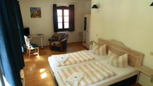 1 Schlafzimmer mit 2 Betten und einem Stuhl in der Unterkunft MB Hotel Weißer Hirsch in Hohnstein
