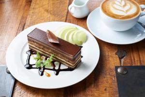 a plate with a chocolate cake and a cup of coffee at Shama Sukhumvit Bangkok in Bangkok