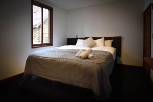 um quarto com uma cama com dois ursinhos de peluche em The Joint em Hakuba