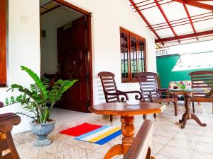 本托塔的住宿－Sahana Sri Villa，门廊,带椅子和桌子,还有植物